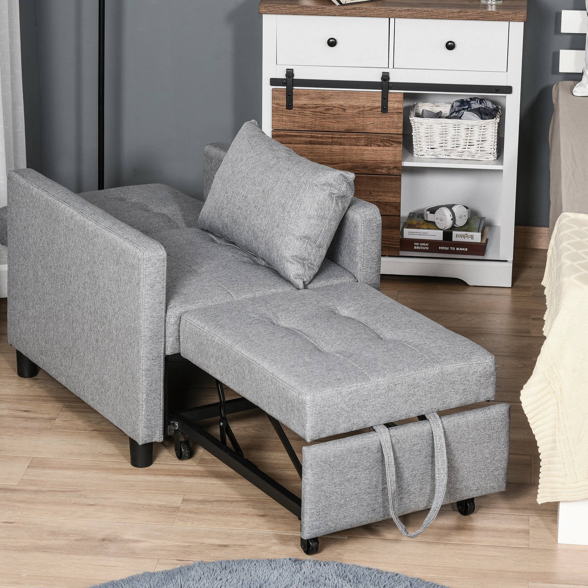Gray upholstered convertible sofa bed with pullout footrest