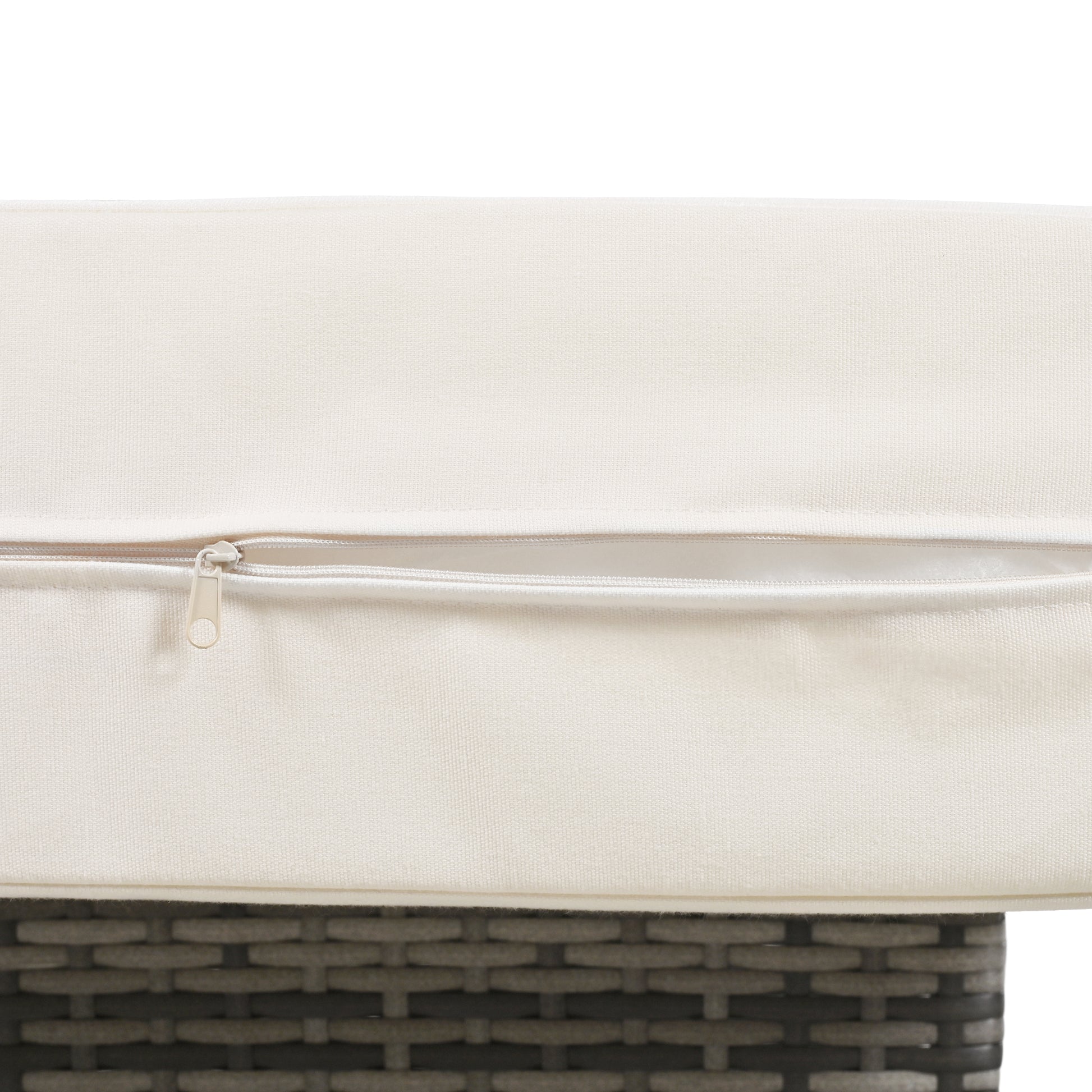 Closeup of ivory outdoor cushion with a white zipper detail on wicker furniture