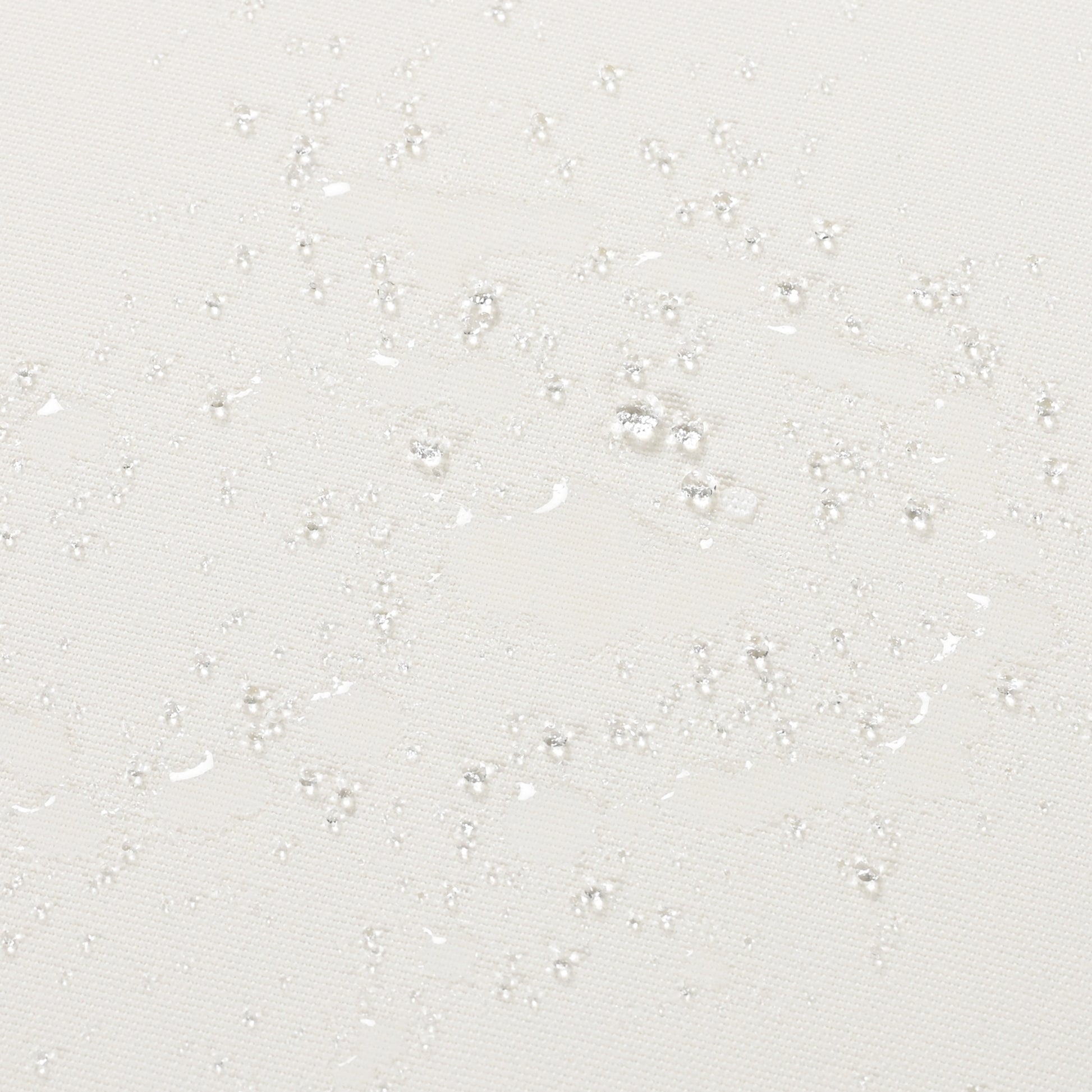 Closeup of a white textured fabric with water droplets showcasing its waterrepellent property