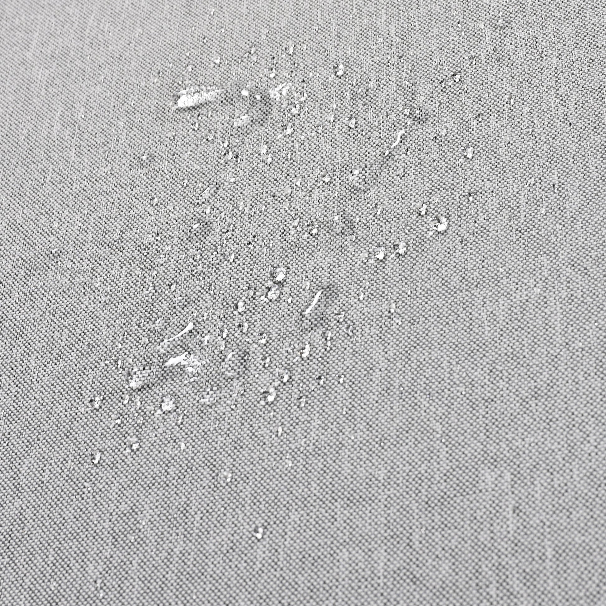 Closeup of water beading on a gray fabric showcasing its waterrepellent quality