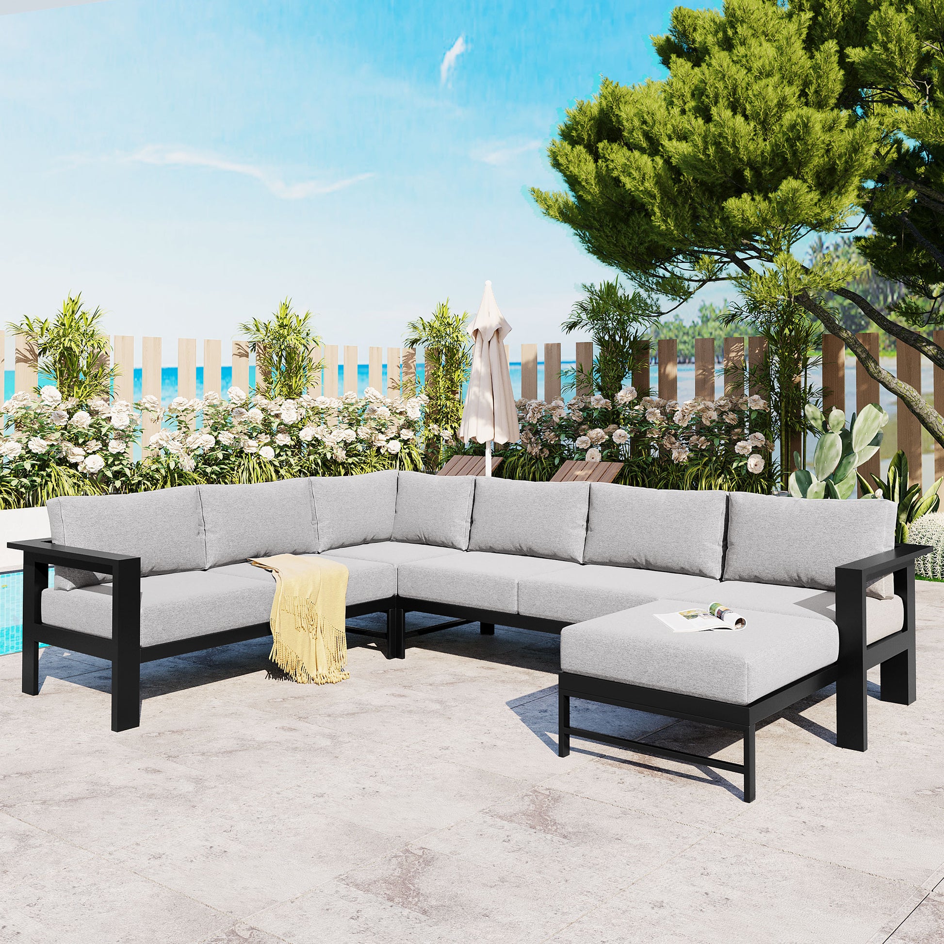 Gray modular outdoor sofa with black frame and yellow throw blanket perfect for patios
