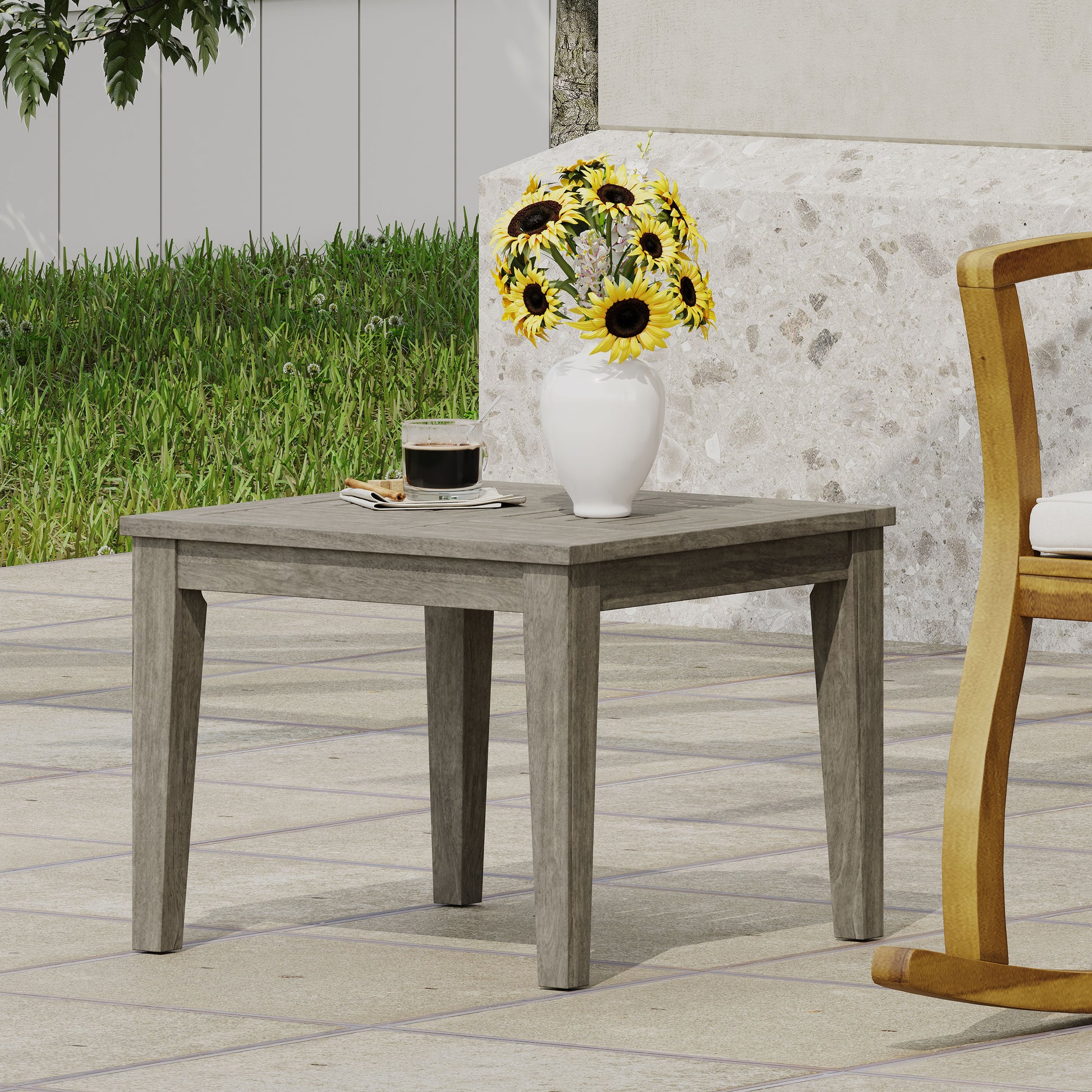 Gray slatted wood patio end table with a white vase of sunflowers