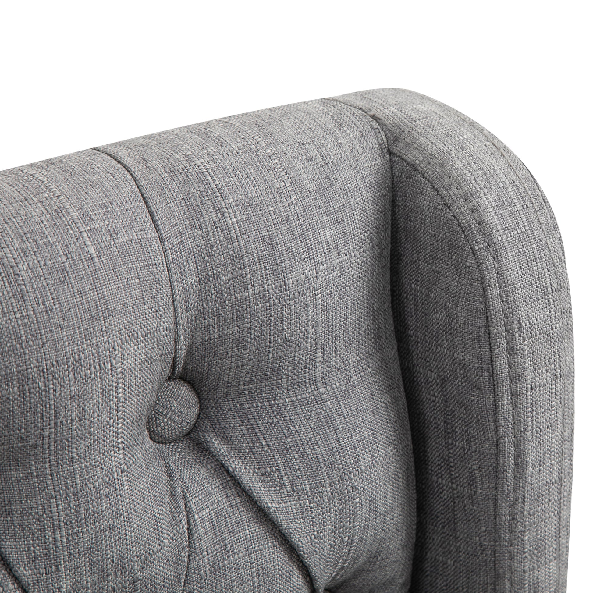 Closeup of grey tufted armchair fabric showing detailed texture and button accent for stylish living room decor
