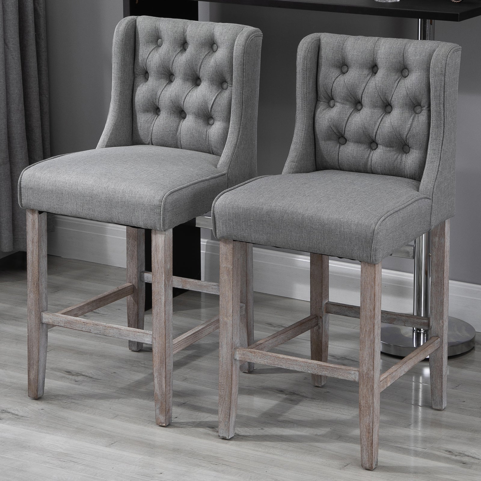 Pair of grey upholstered tufted back bar stools with distressed wood legs