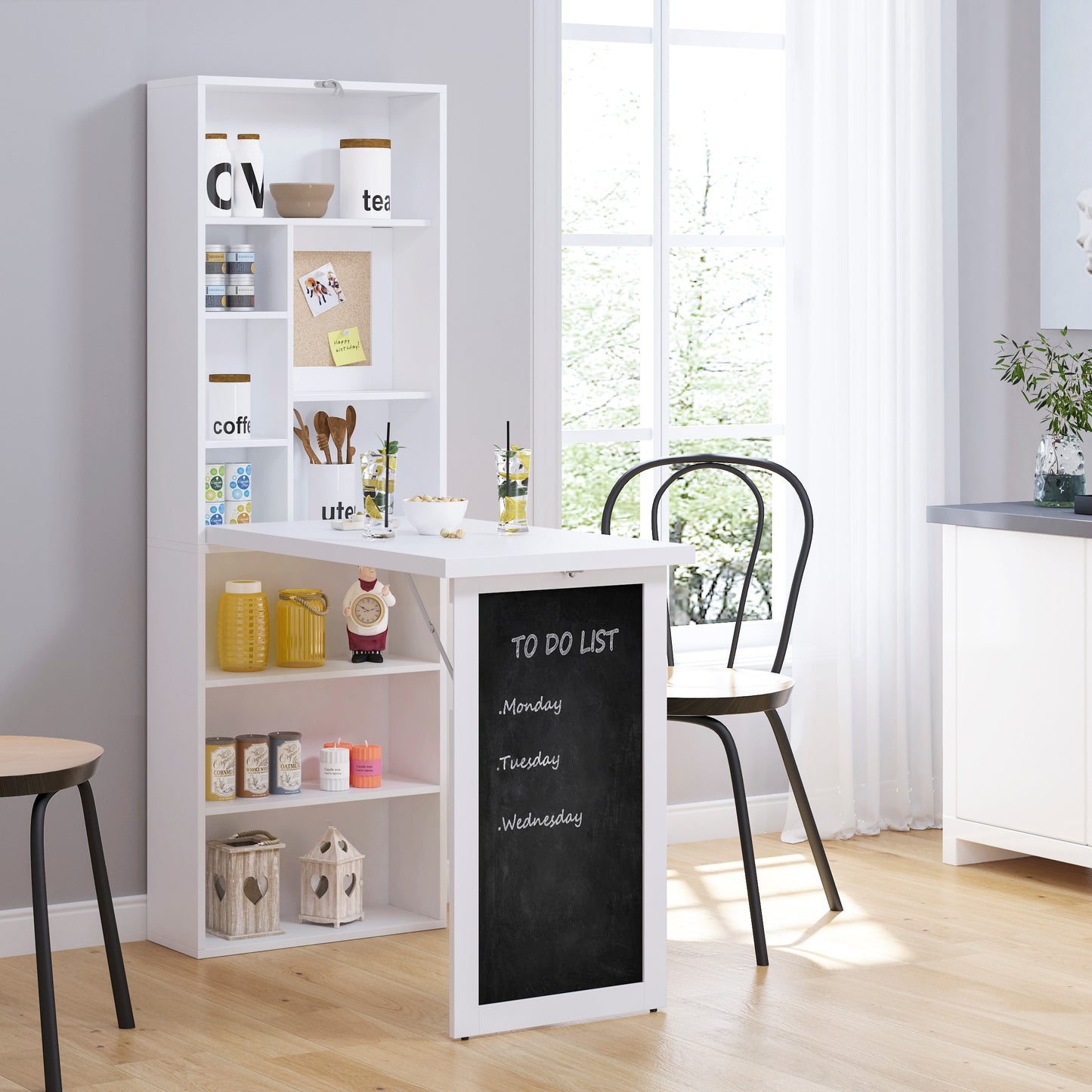 White wallmounted folddown desk with chalkboard and shelves displaying kitchen items