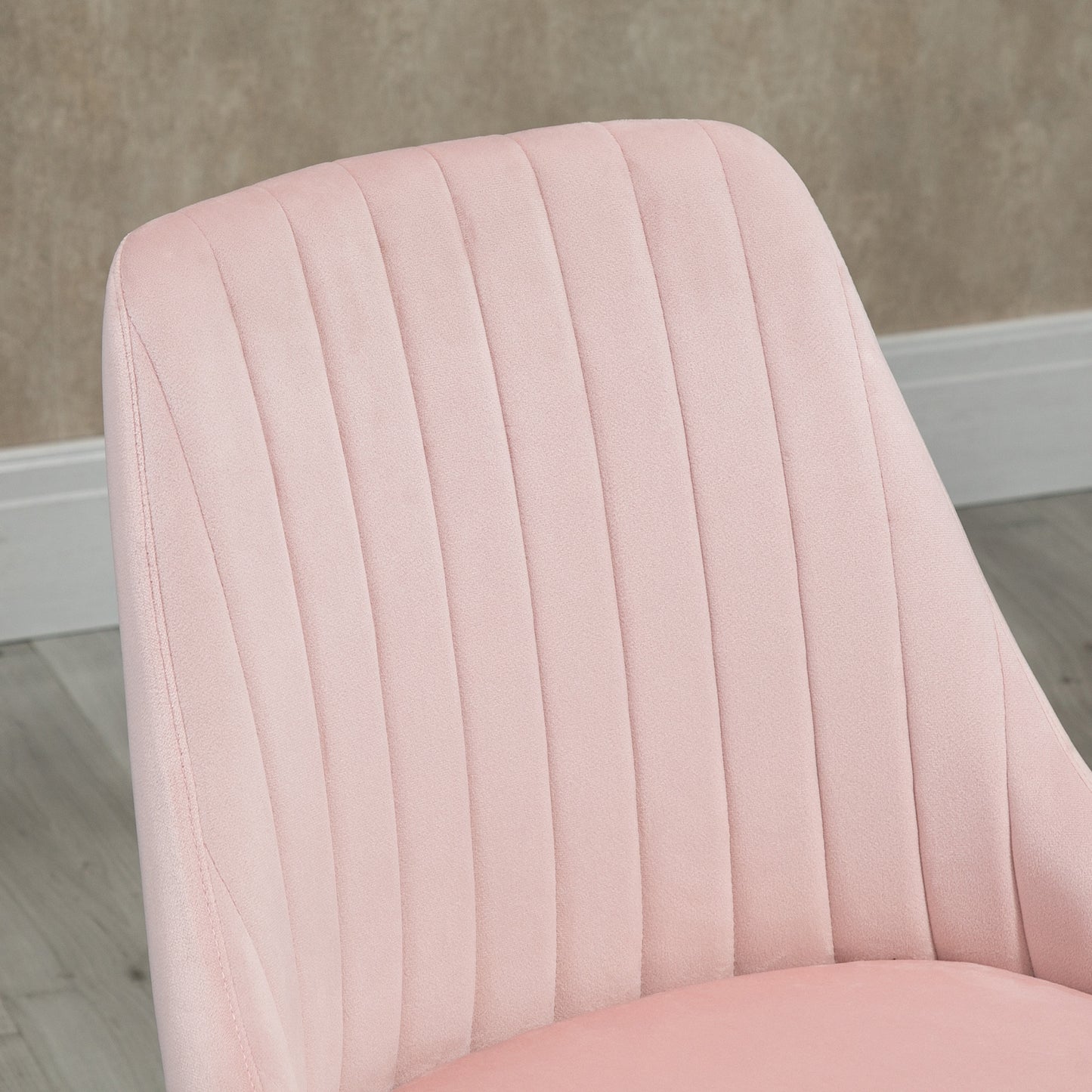Closeup of plush pink velvet chair back with vertical channel tufting