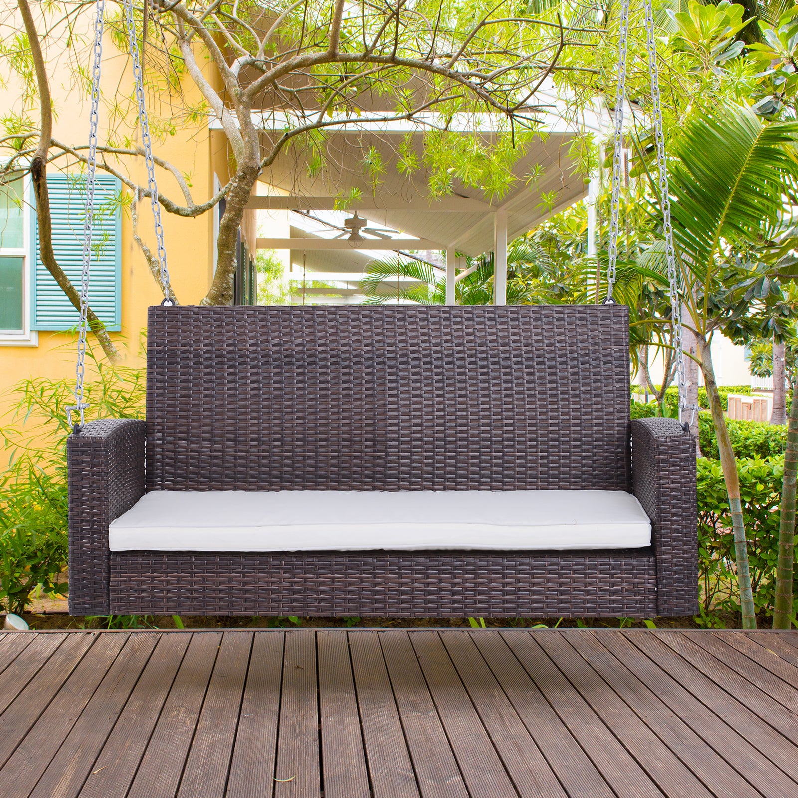 Dark brown rattan swing chair with white cushion ideal for outdoor seating