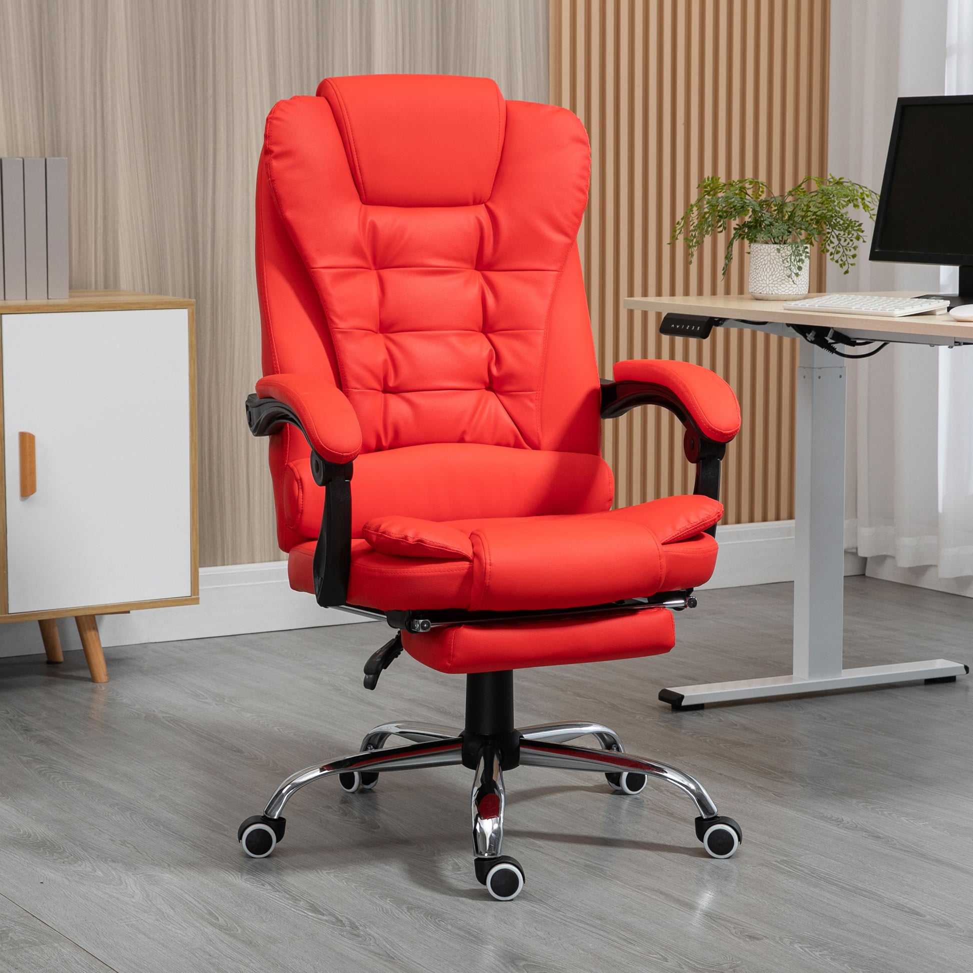 Ergonomic red office chair with plush cushioning and adjustable footrest for ultimate comfort