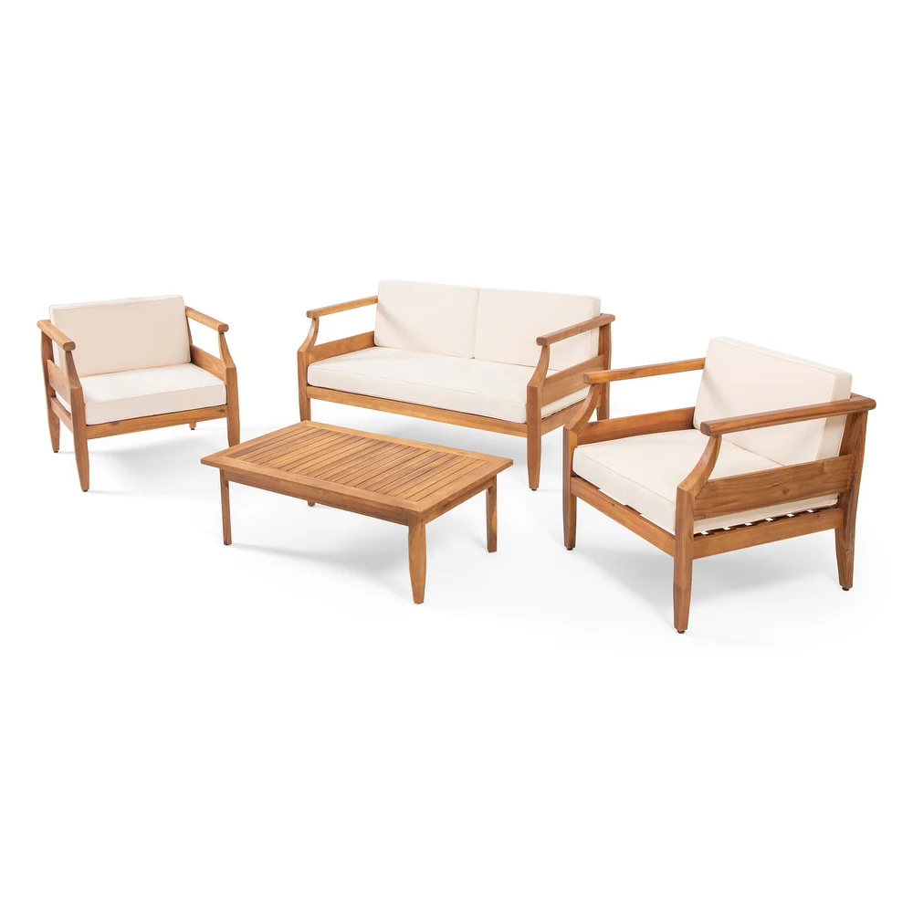 Teak wood patio furniture set with cream cushions including a sofa two chairs and a coffee table
