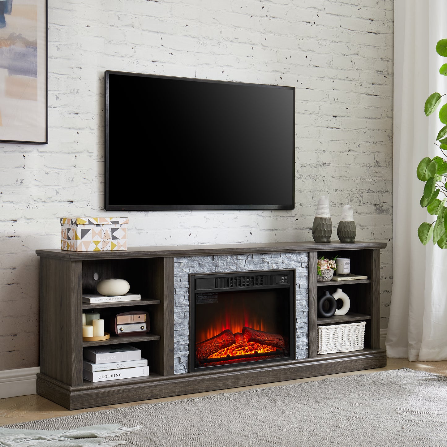 Gray wood fireplace TV stand with faux stone surround and realistic electric flames