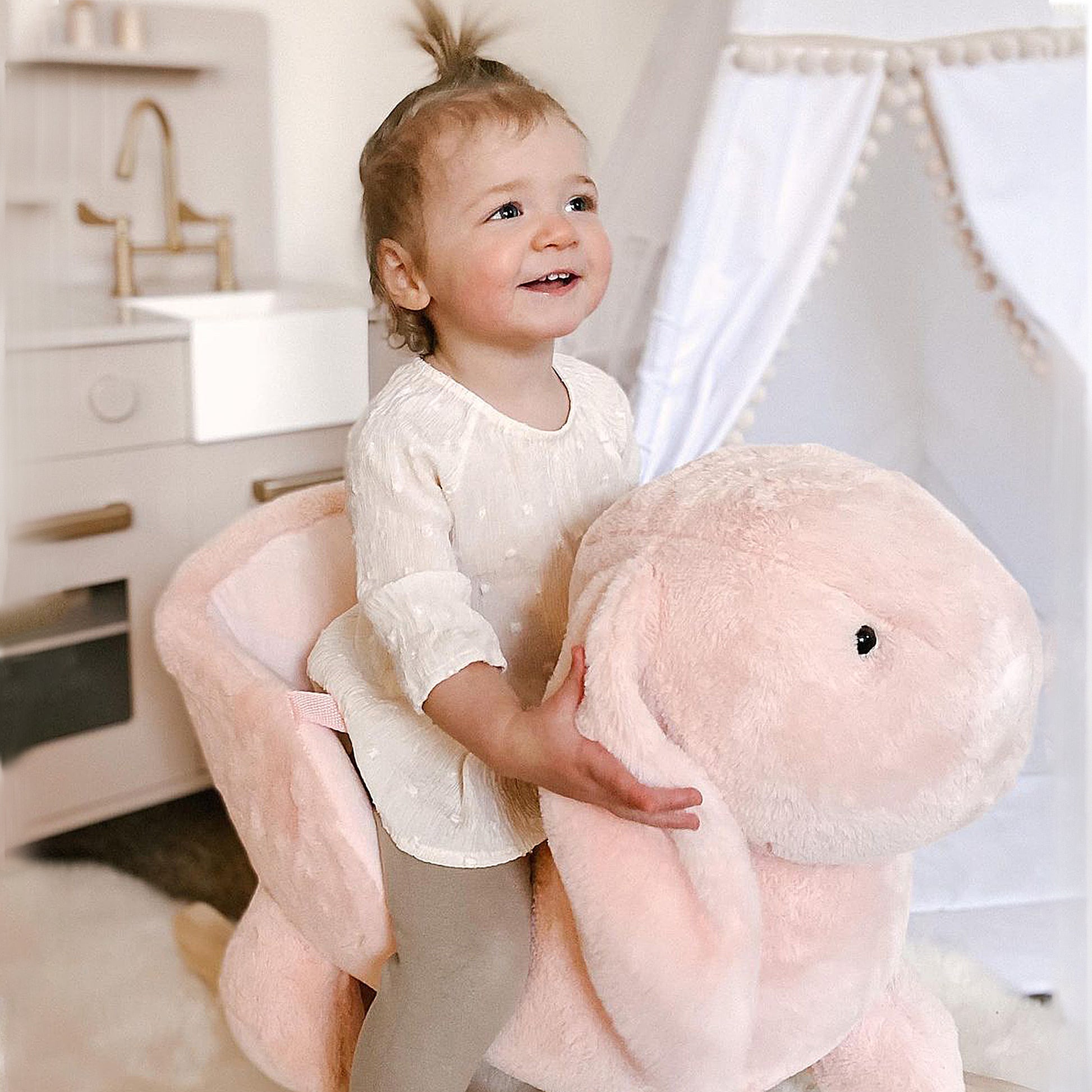 Plush pink bunny rocker with a toddler girl perfect for nursery decor
