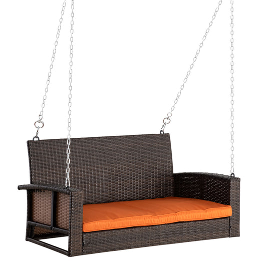 Brown wicker porch swing with orange seat cushion suspended by silver chains