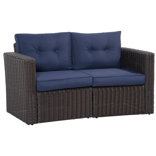 Dark brown wicker loveseat with tufted navy blue cushions and arms