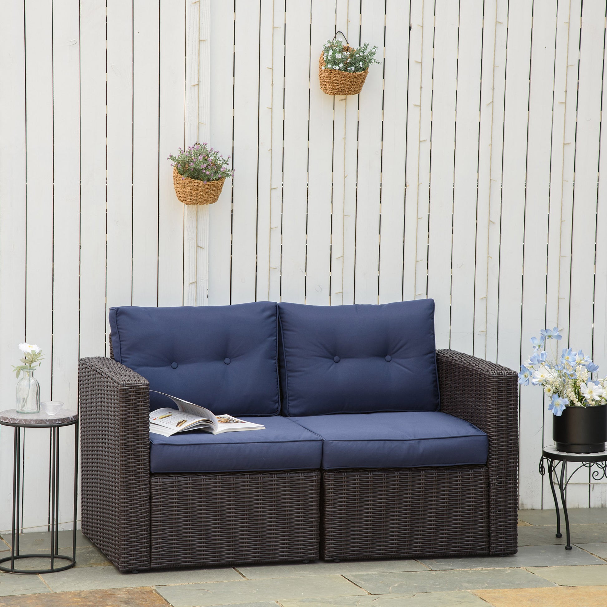 Dark brown wicker loveseat with navy blue tufted cushions perfect for outdoor seating
