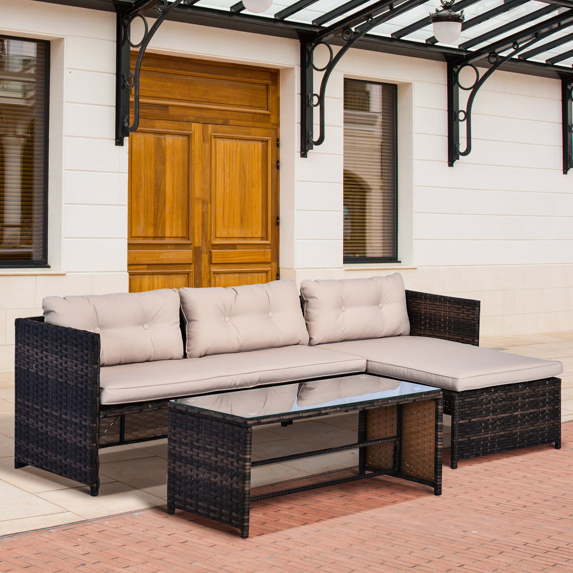 Dark brown rattan sectional sofa with beige cushions and glass coffee table