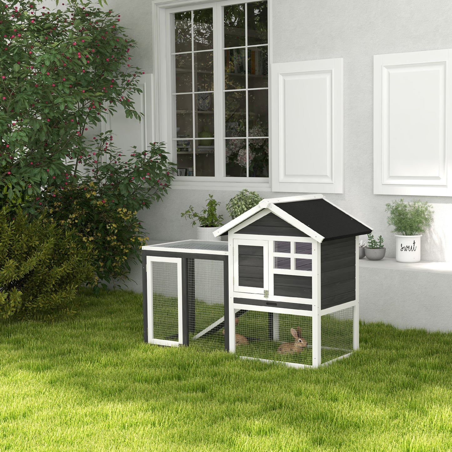 Twotier dark gray and white wooden rabbit hutch with wire mesh sides and two rabbits inside