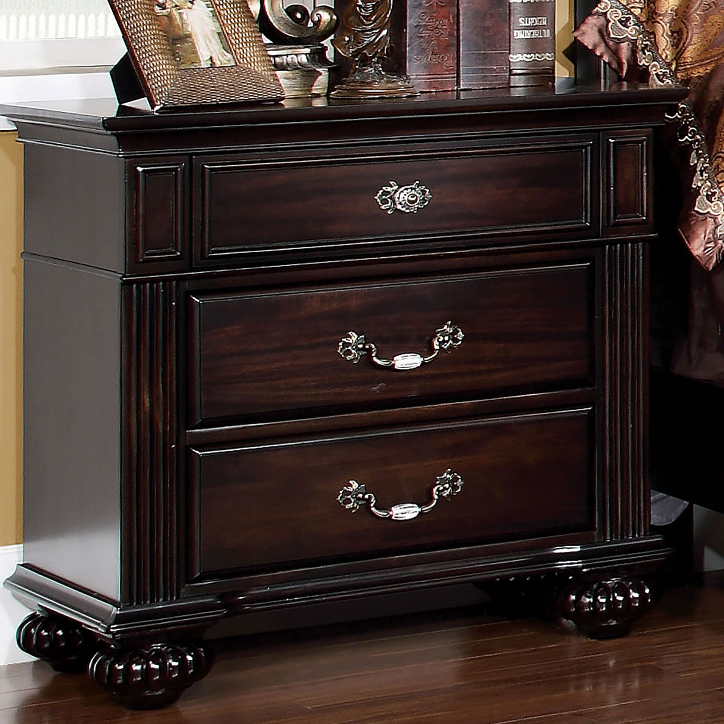 Dark brown traditional nightstand with three drawers and ornate silver pulls