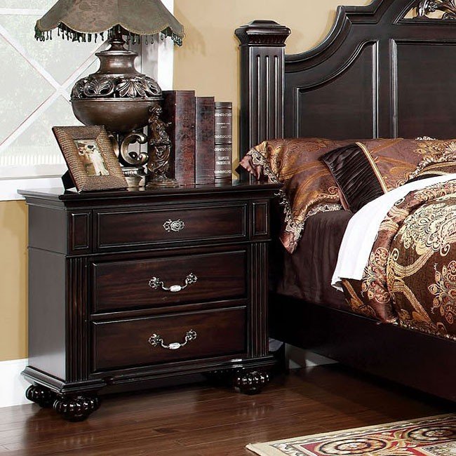 Dark cherry wood nightstand with three ornate drawers and carved legs
