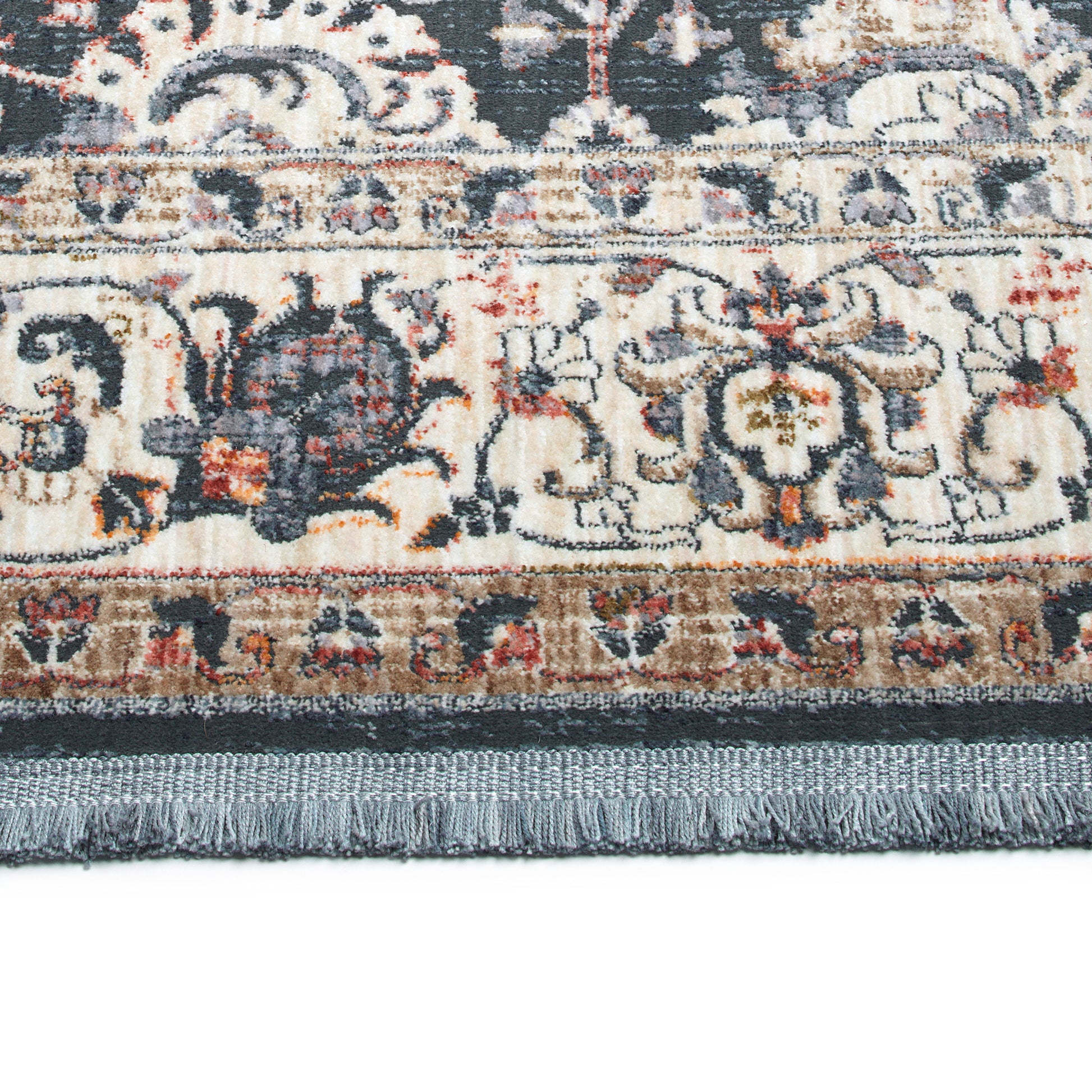 Closeup of a cream and grey oriental rug with ornate floral patterns and fringe detailing