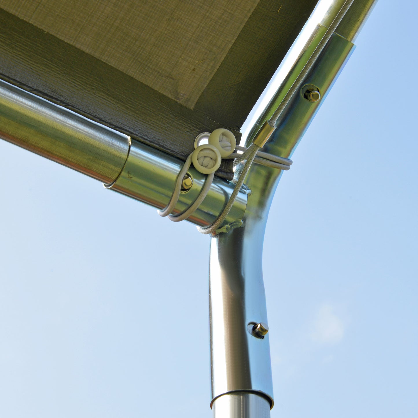 Closeup of green tarp secured to galvanized steel frame with bungee cords