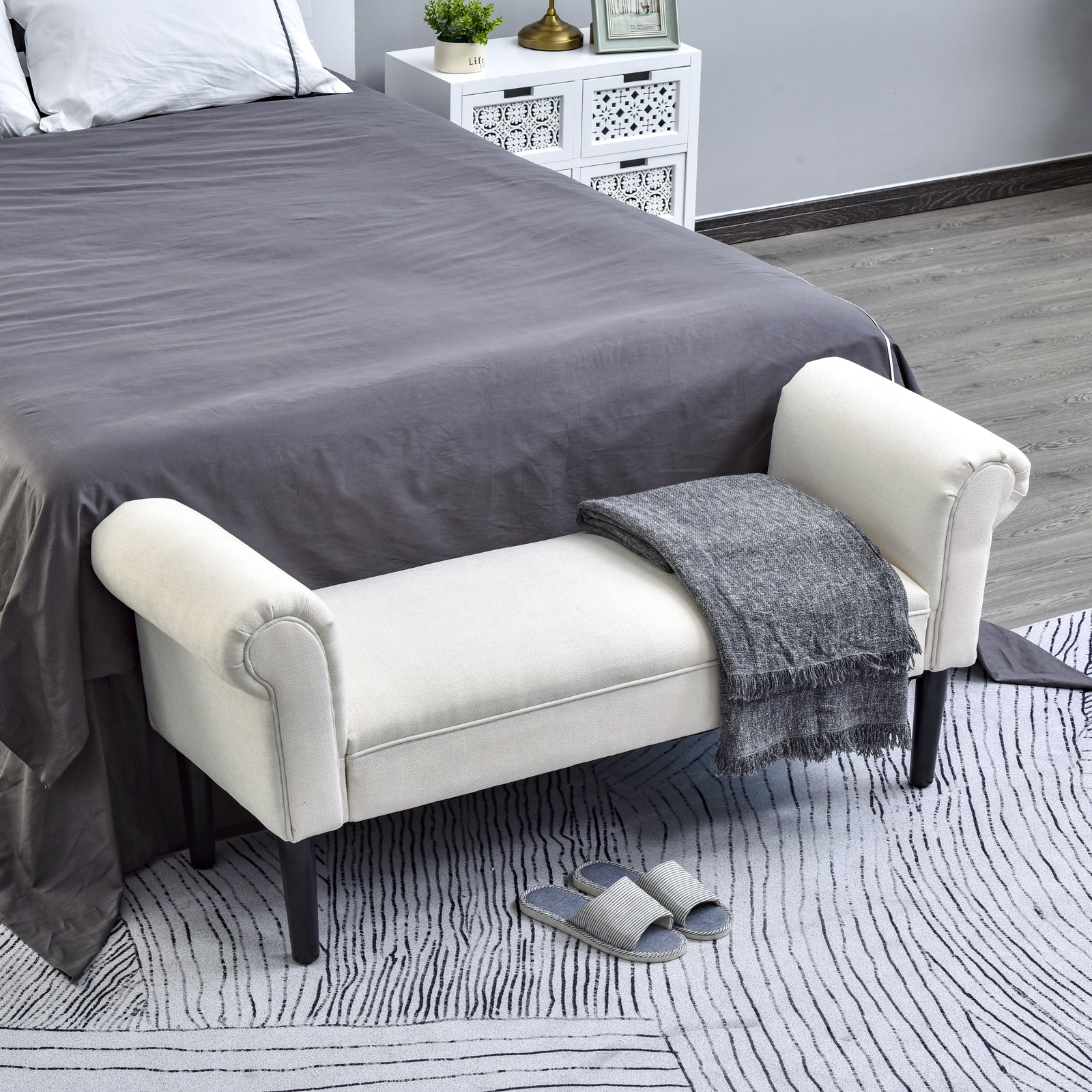 Cream linen upholstered bench with rolled arms and dark wood legs