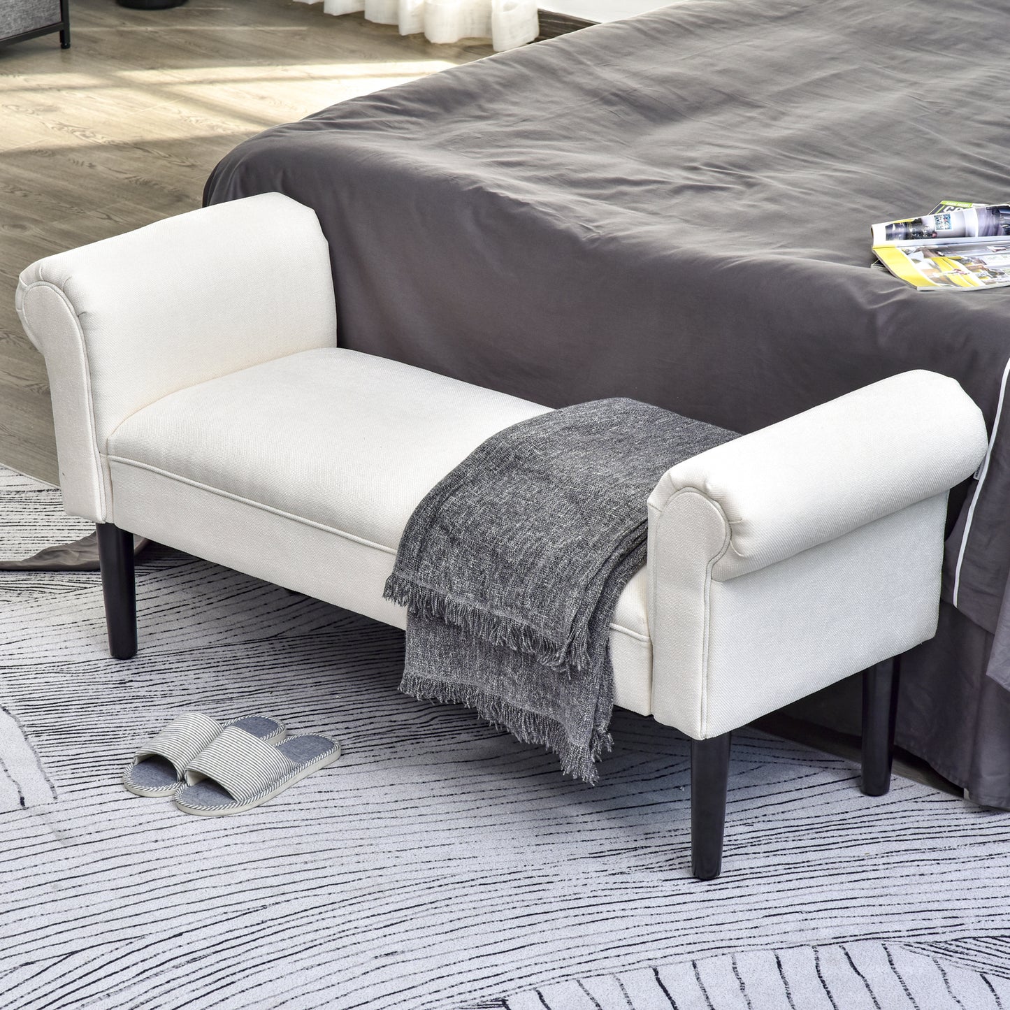 Cream upholstered accent bench with rolled arms and dark wood legs
