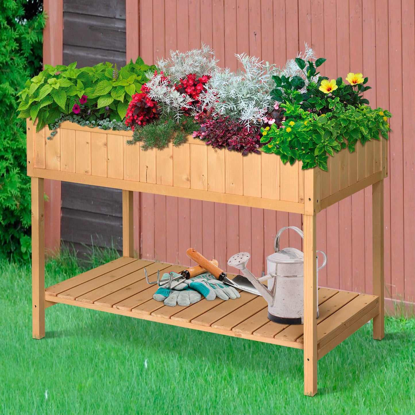 Wooden raised garden bed filled with lush green plants red flowers and silver foliage