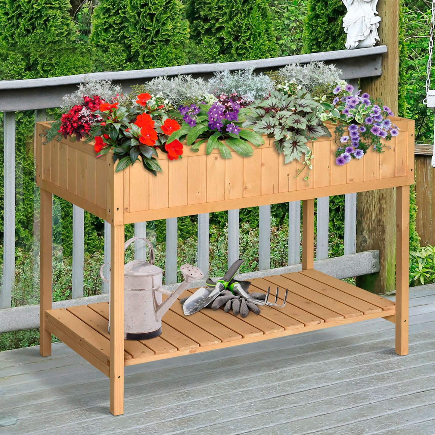 Wooden raised garden bed filled with red and purple flowers includes gardening tools