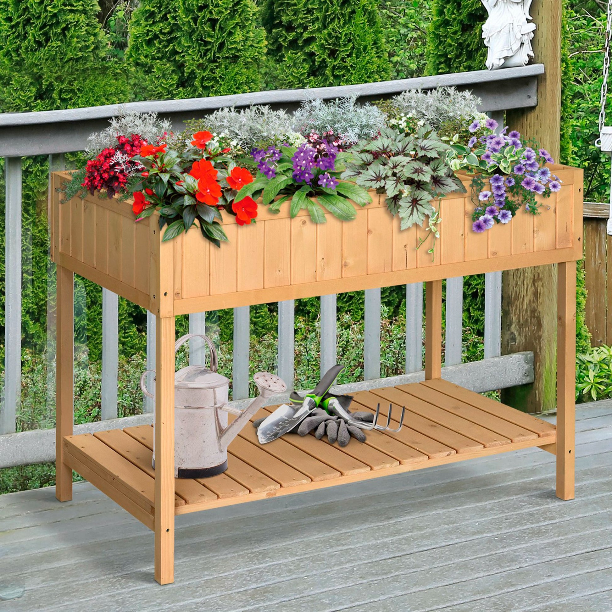 Wooden raised garden bed filled with red and purple flowers includes gardening tools