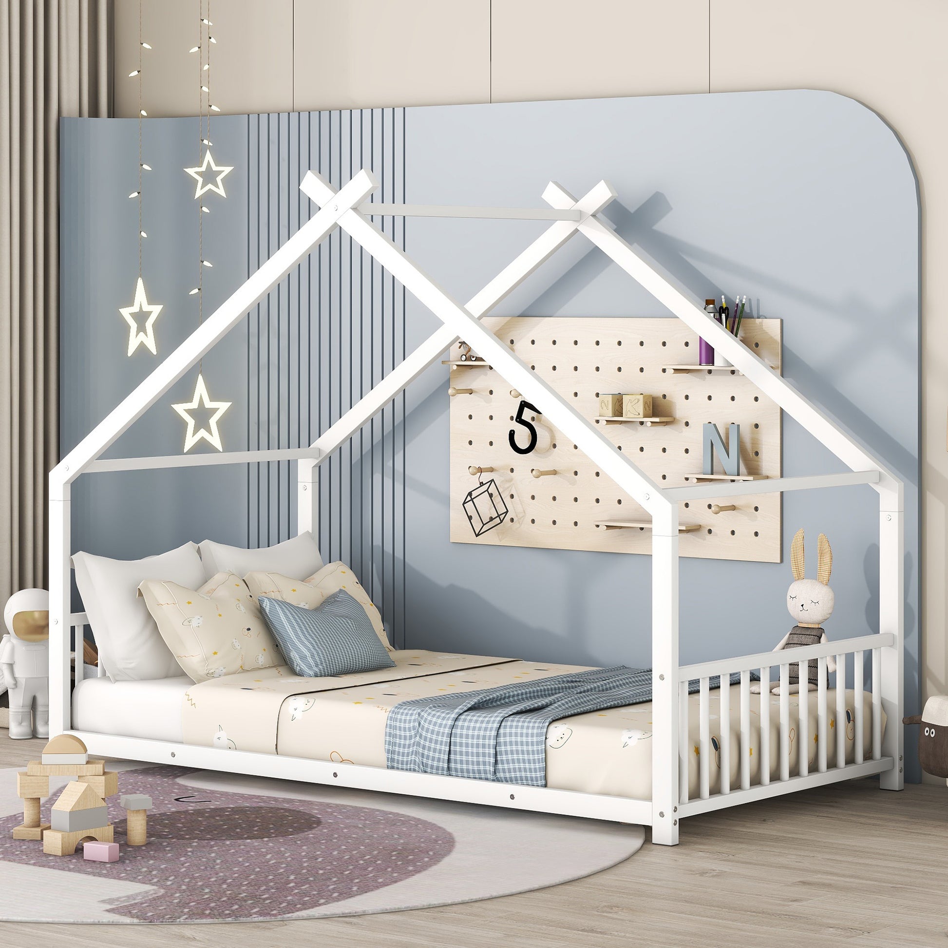 White wooden house bed frame with playful bedding and stuffed animals
