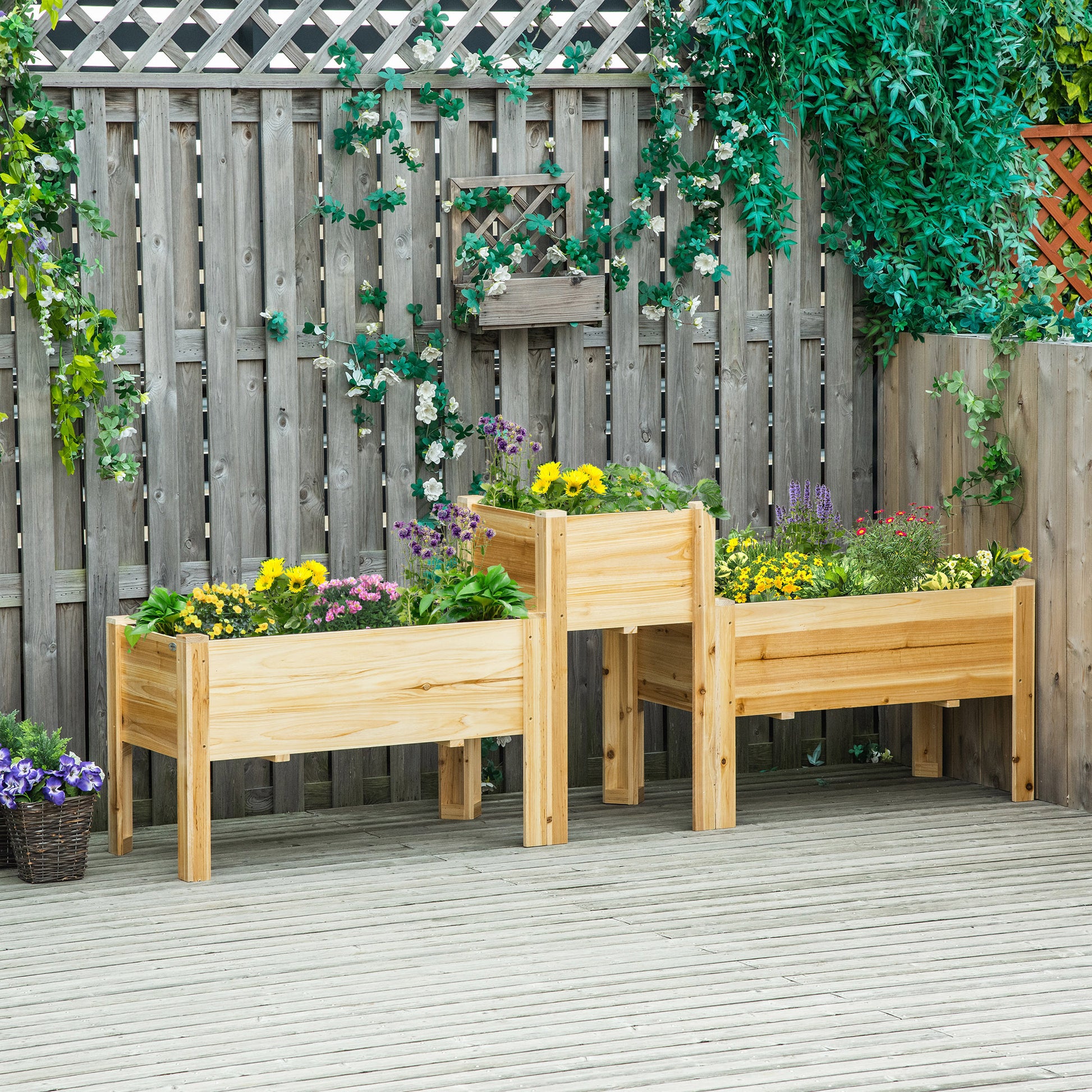 Three wooden raised garden beds filled with colorful flowers and plants