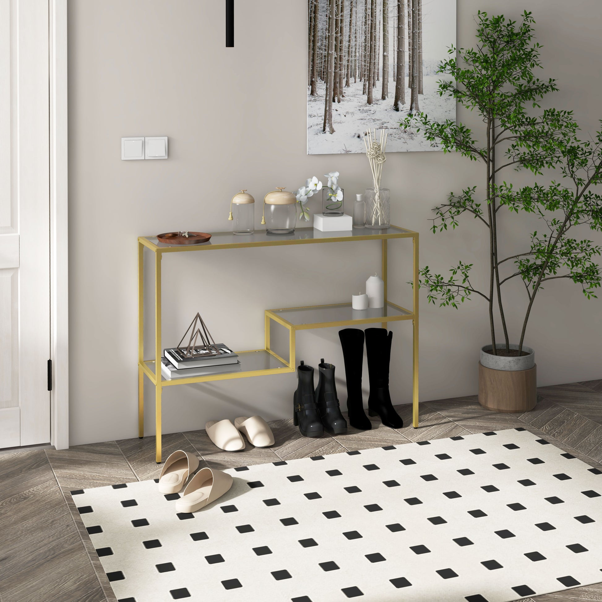 Gold console table with clear glass shelves holding decorative jars and books
