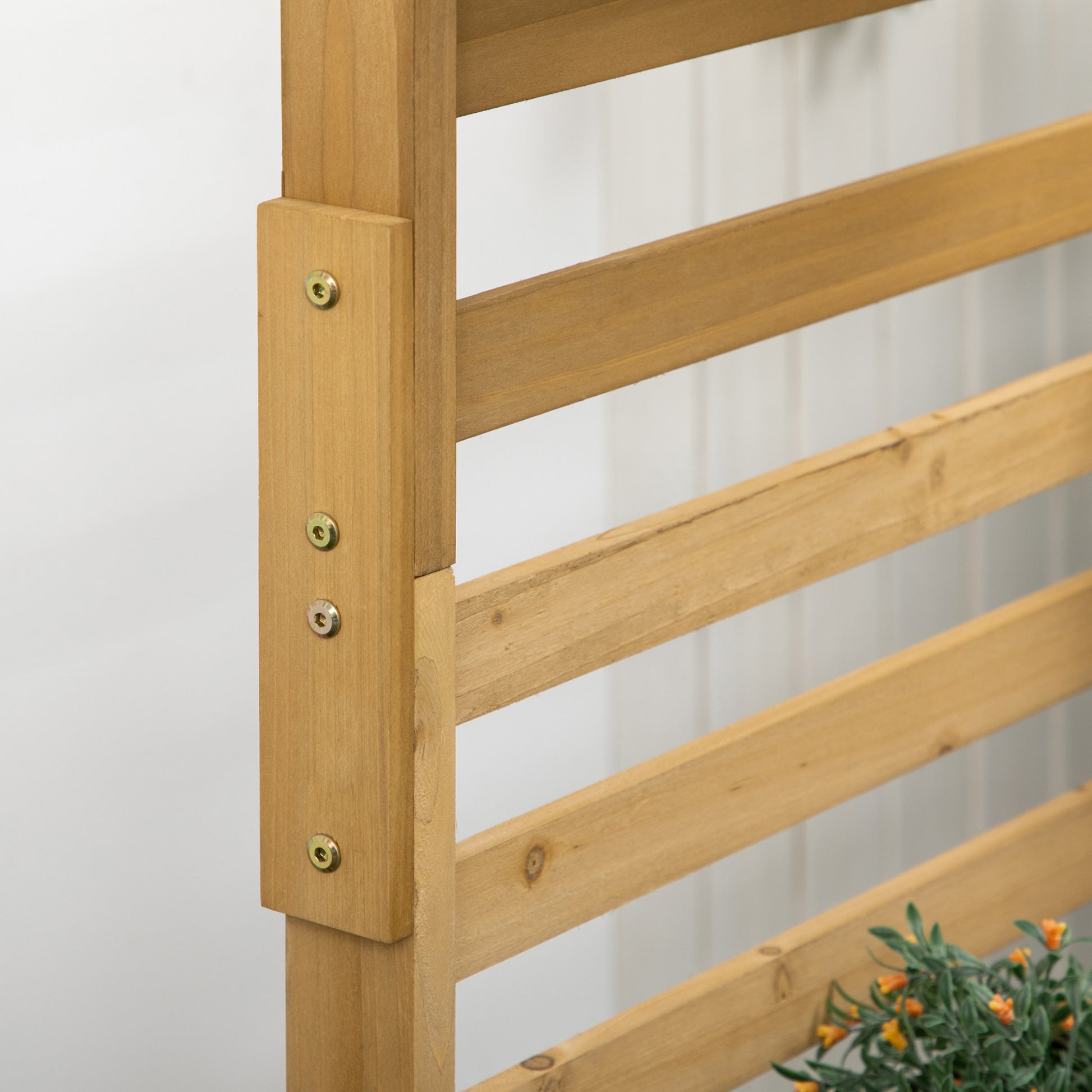 Closeup of a natural wood garden trellis with horizontal slats and metal fasteners for climbing plants