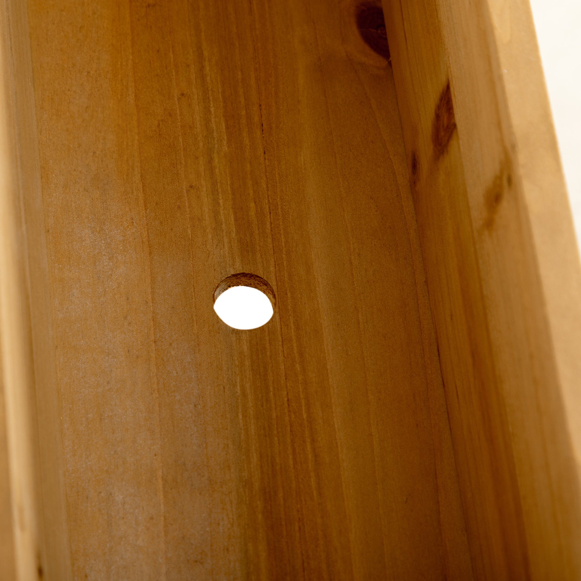 Closeup of natural wood grain with a small circular bore hole