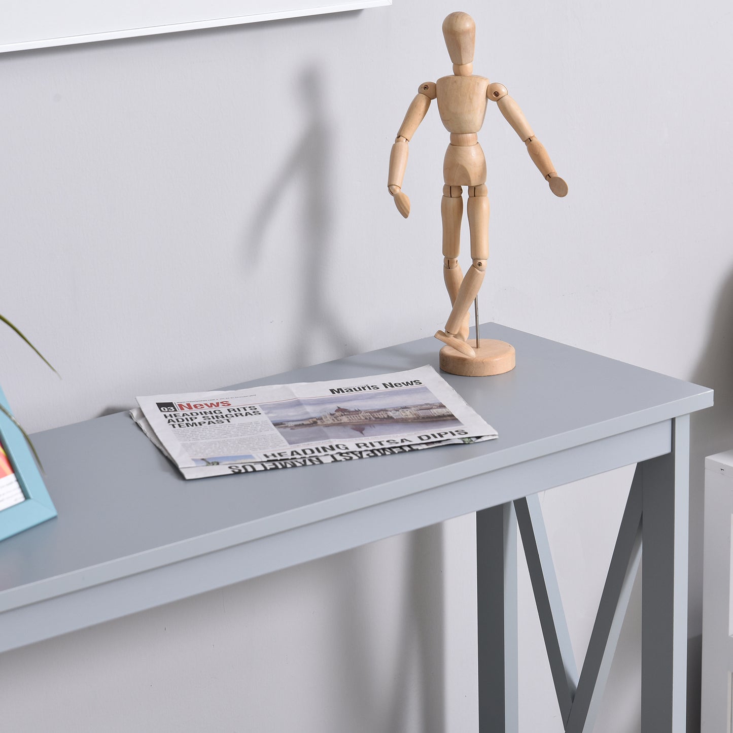 Wooden artist mannequin posed dynamically on a grey table a prop for artists