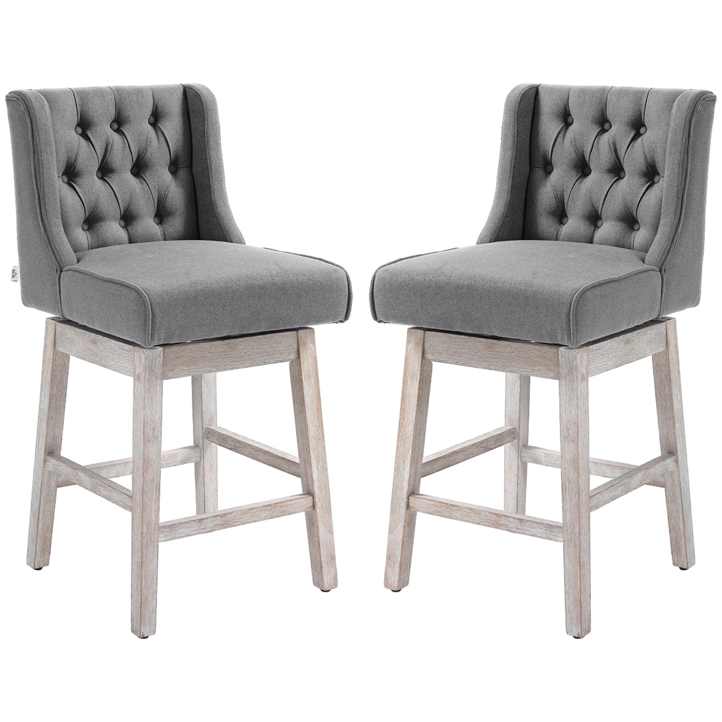 Two grey fabric tufted swivel bar stools with distressed wooden legs perfect for a modern kitchen island
