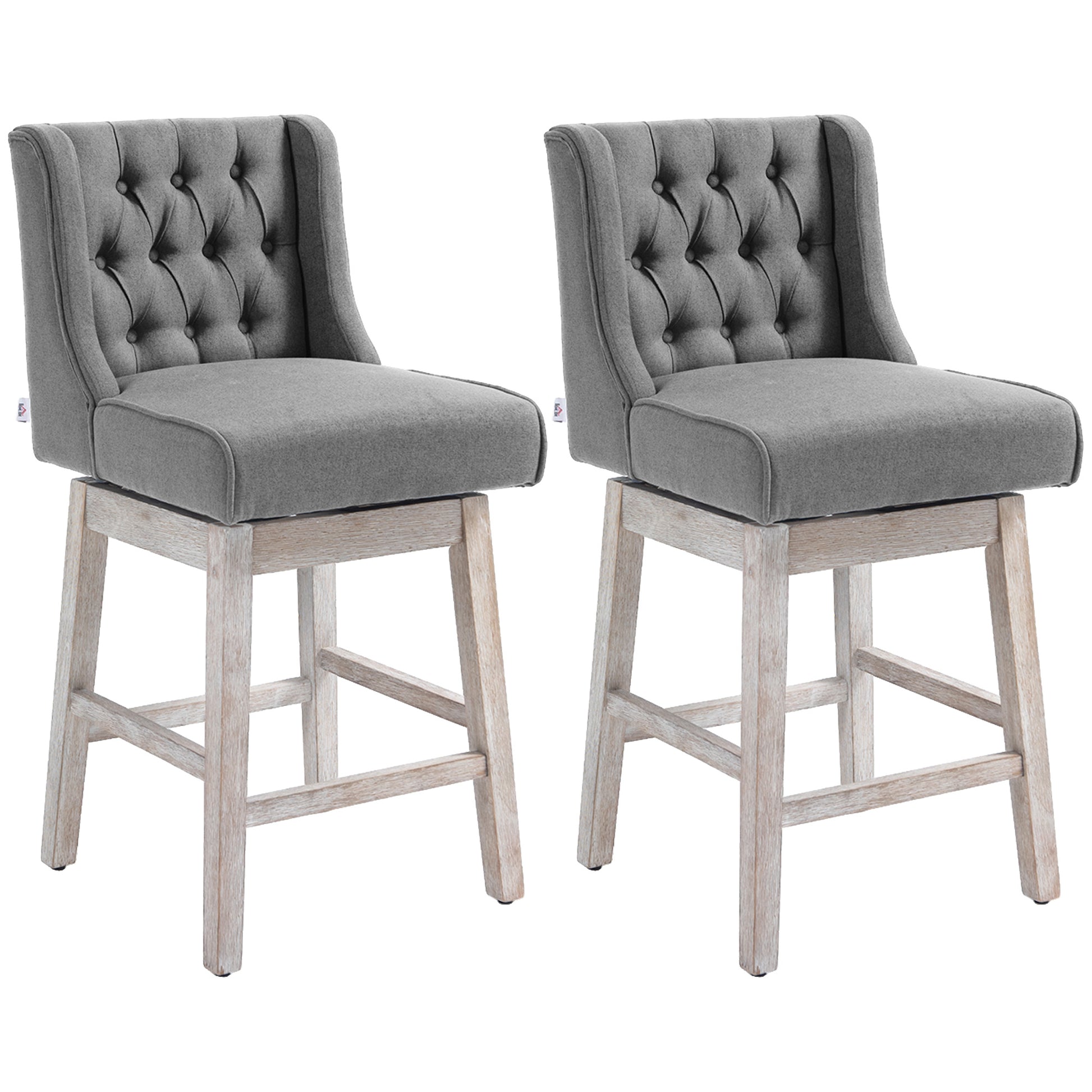 Two gray upholstered bar stools with tufted backs and weathered wood bases