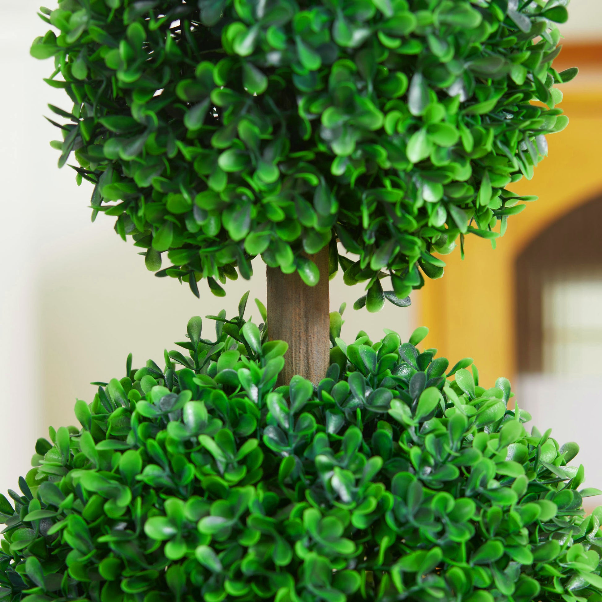 Closeup of a doubleball artificial topiary tree with lush green foliage