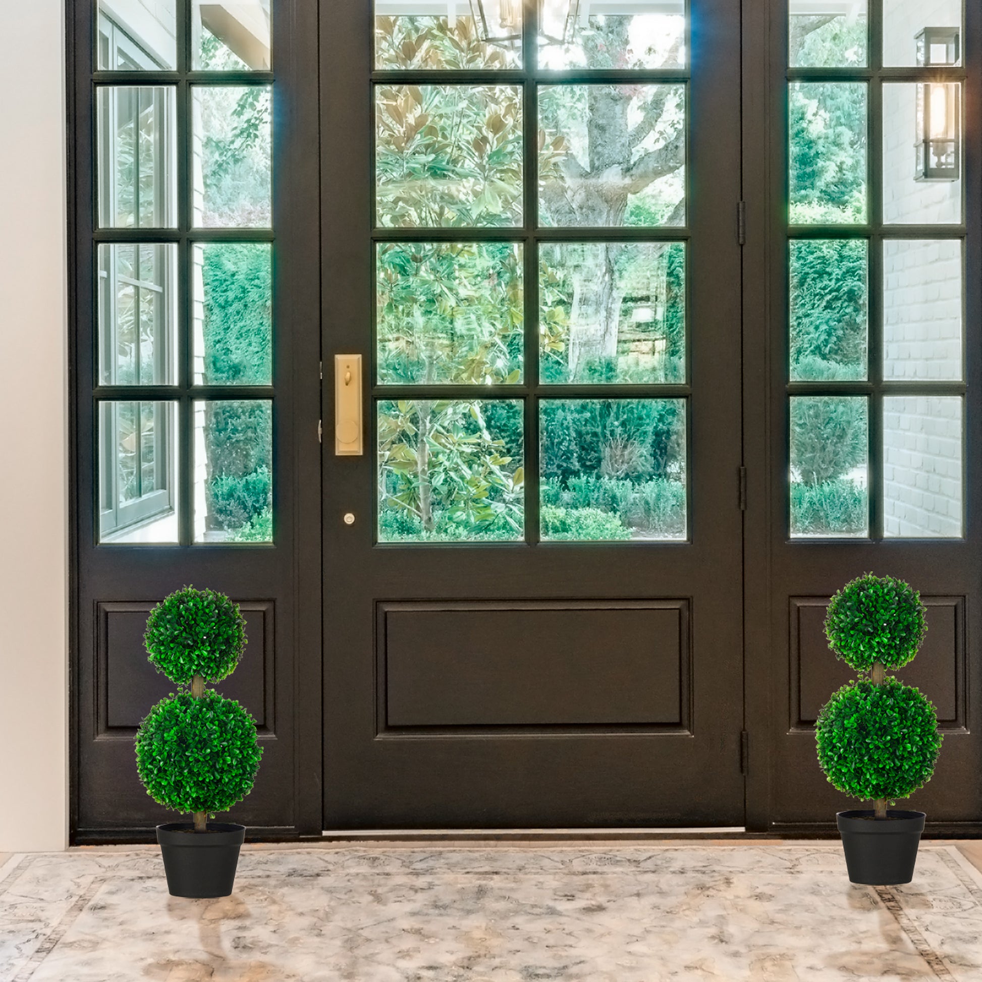 Twotiered artificial boxwood topiary in a black pot for entryway decor