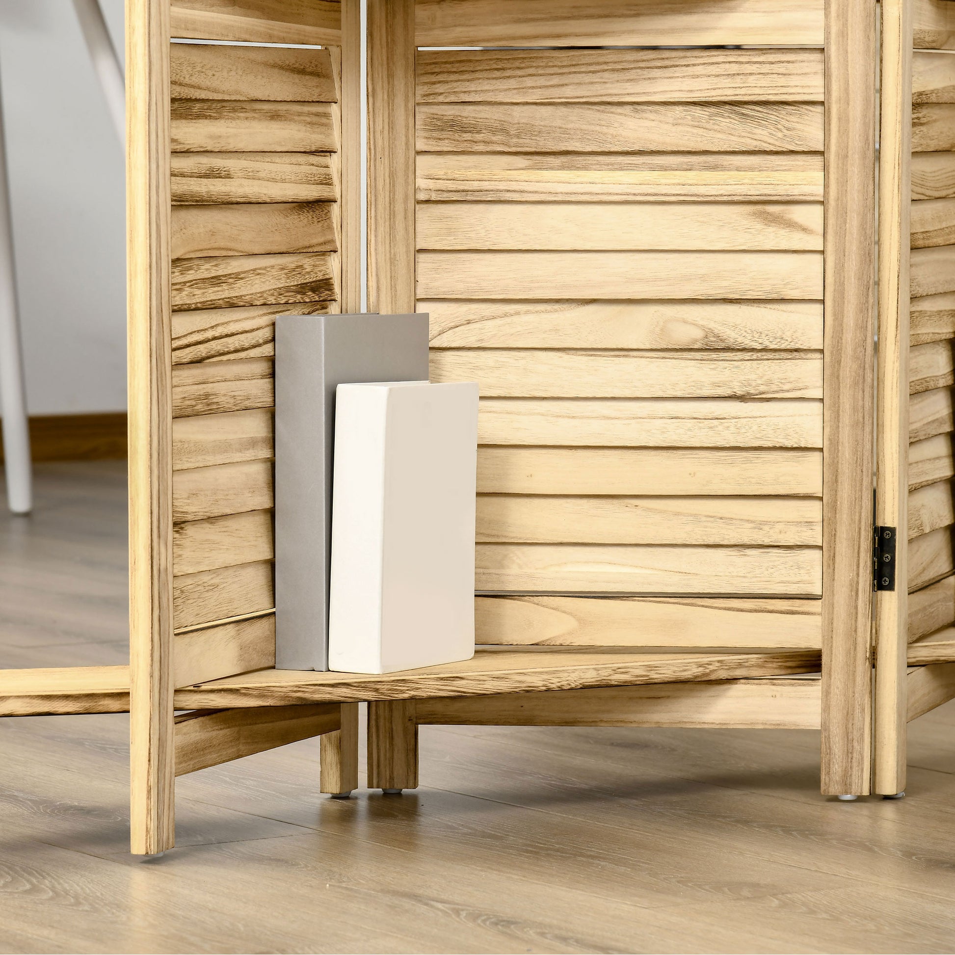 Natural wood room divider with slatted panels and two decorative books