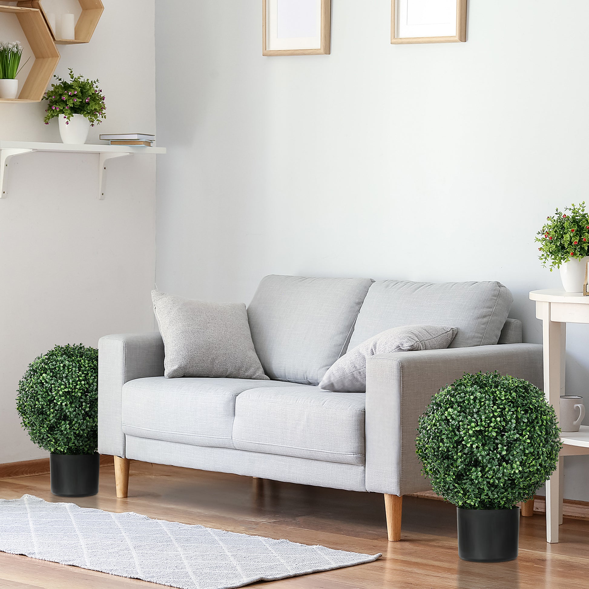 Realistic artificial topiary ball lush green foliage in a black planter for home decor