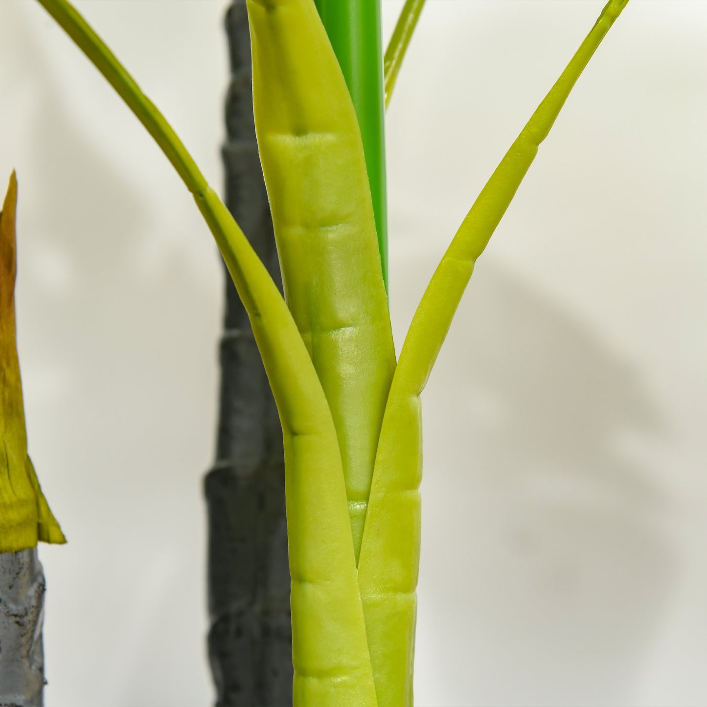 Closeup of a vibrant green faux plant stalk with ribbed texture for home decor
