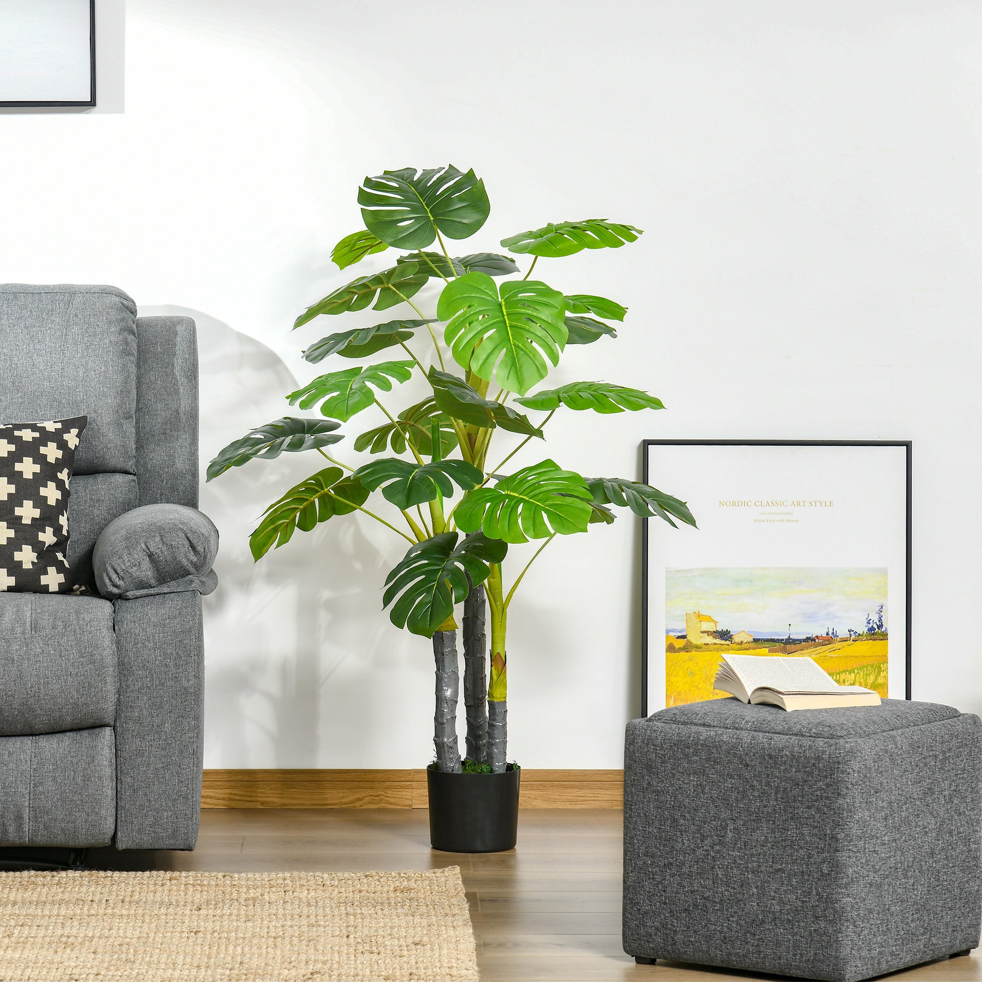 Large artificial monstera plant with vibrant green leaves in a black pot