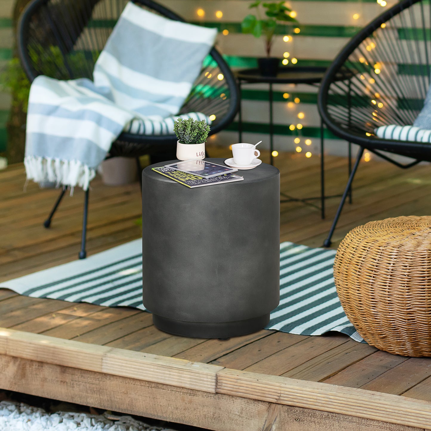 Dark gray round concrete side table with a textured finish on a wooden deck