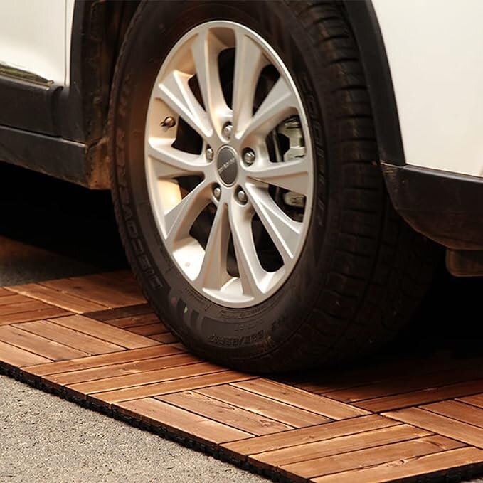 Brown interlocking deck tiles with herringbone pattern under car tire