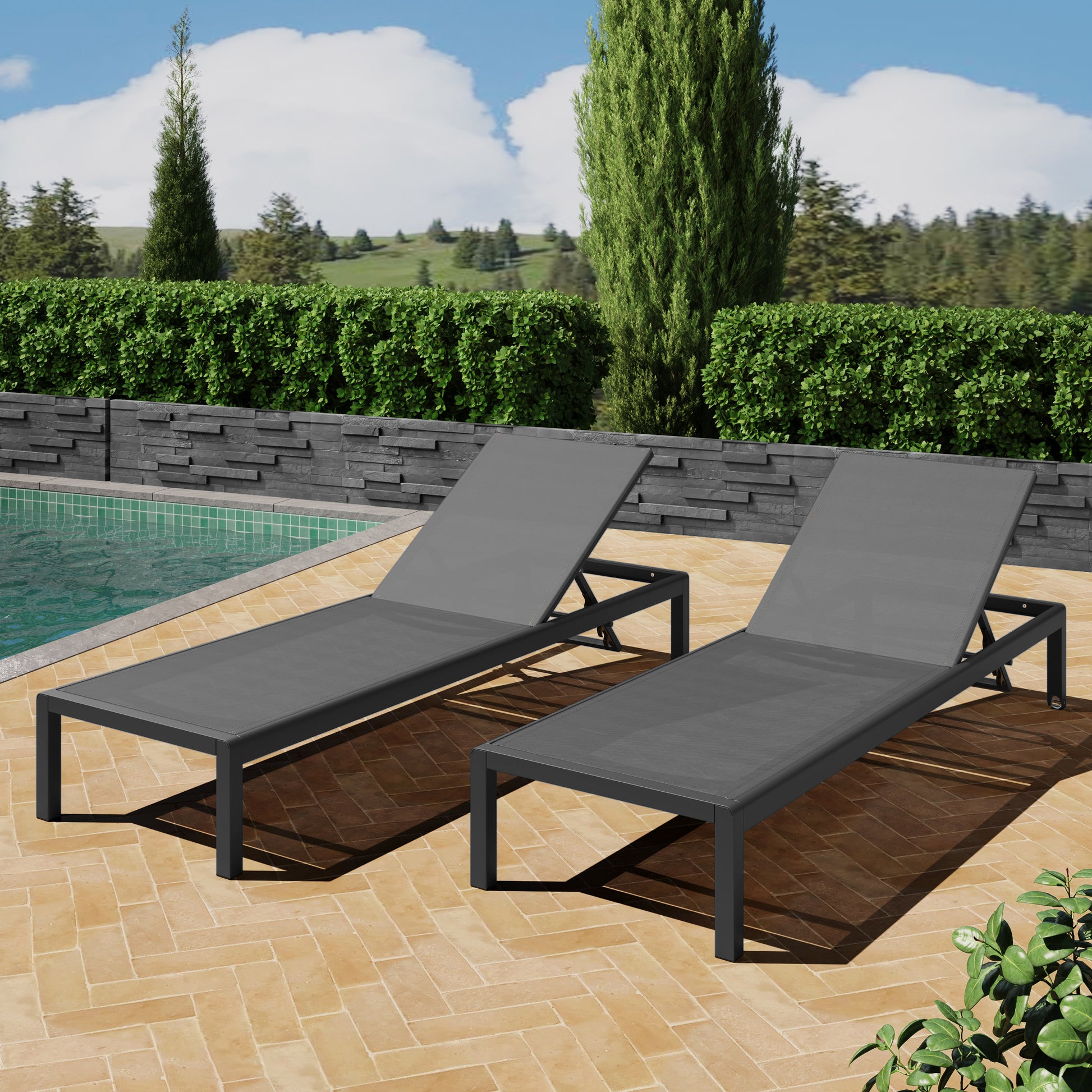 Two modern grey aluminum chaise lounges with fabric mesh seating by a pool