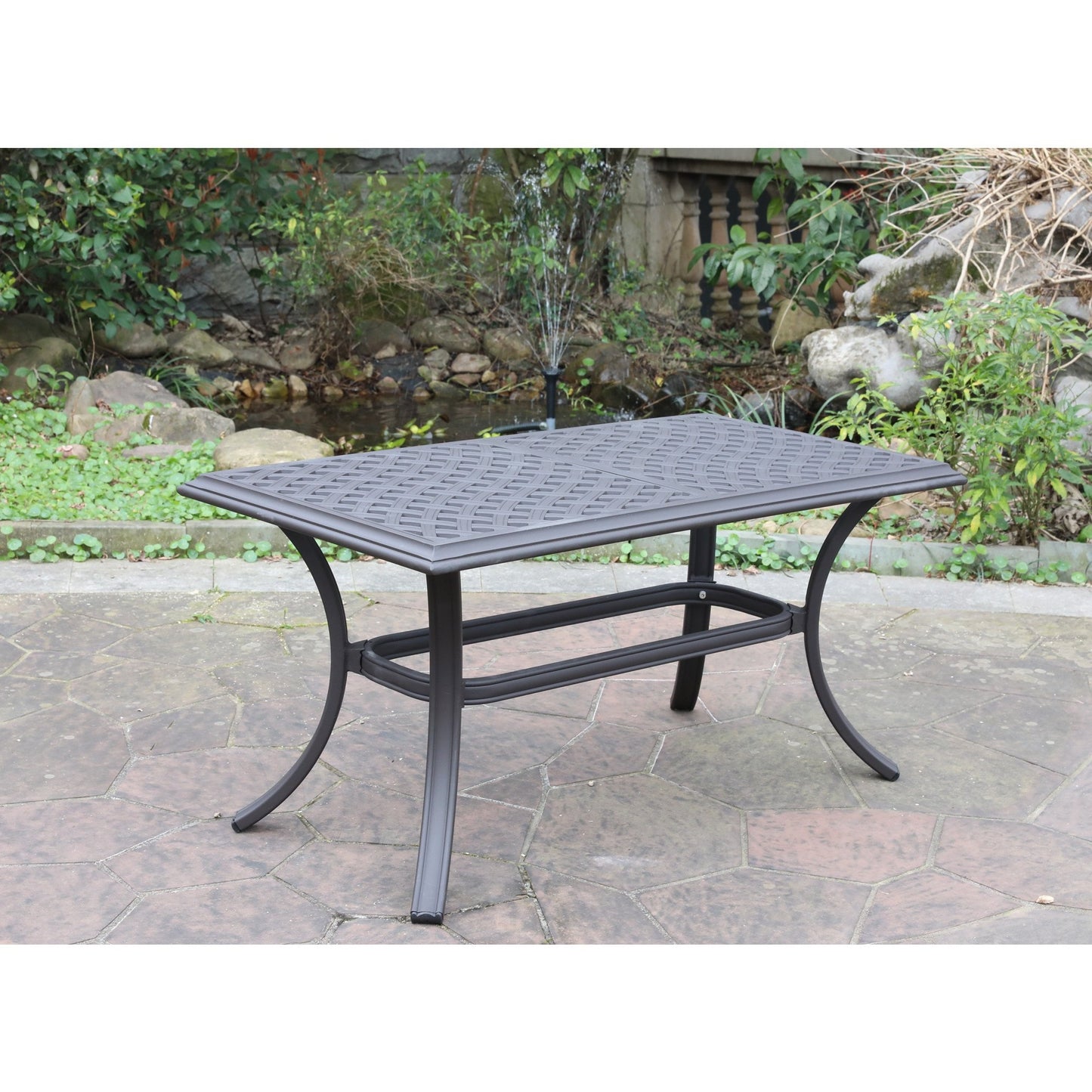 Bronze metal patio dining table with woven design tabletop on paved patio