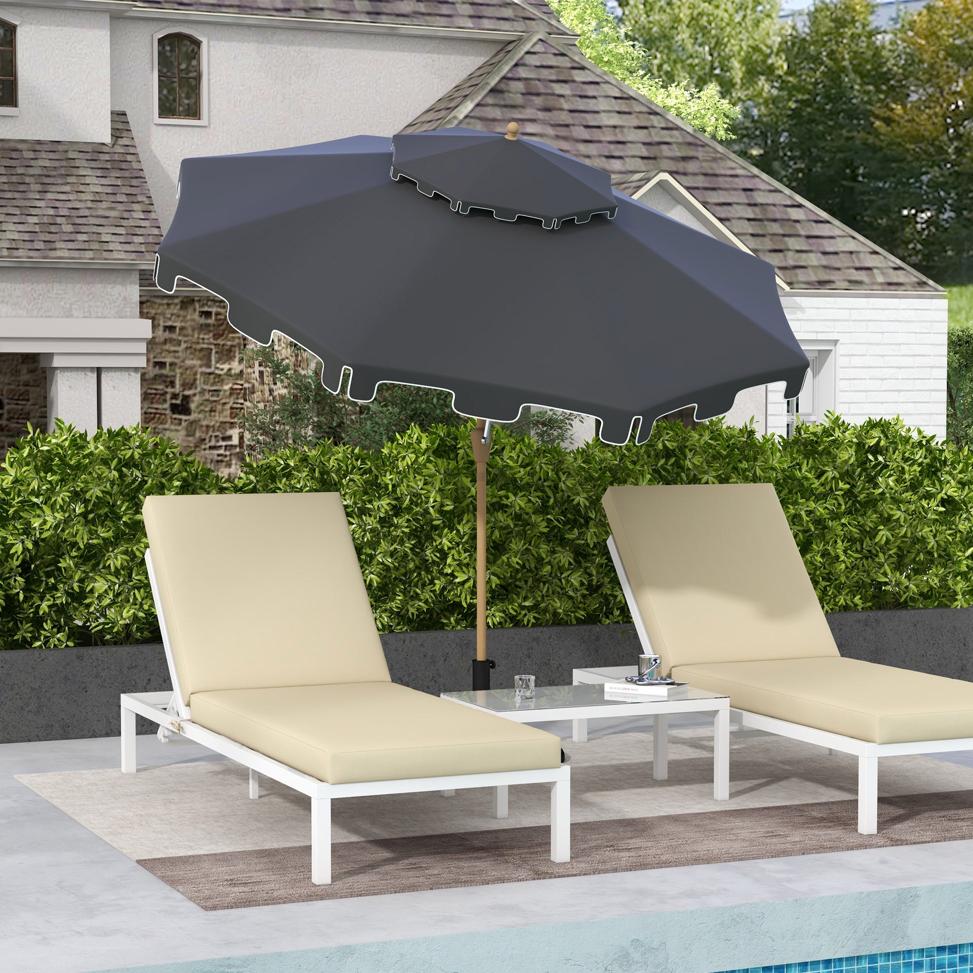 Two beige outdoor chaise lounges with white frames under a dark grey umbrella