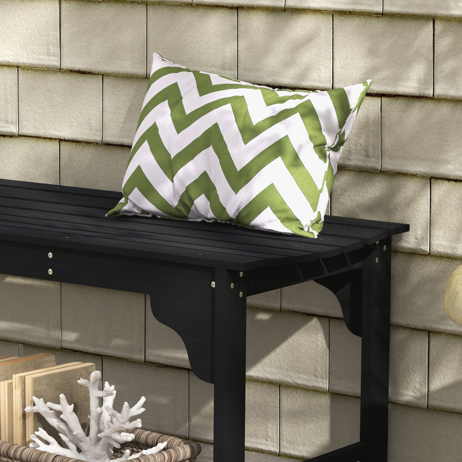 Black wood porch bench with green chevron pillow for outdoor seating