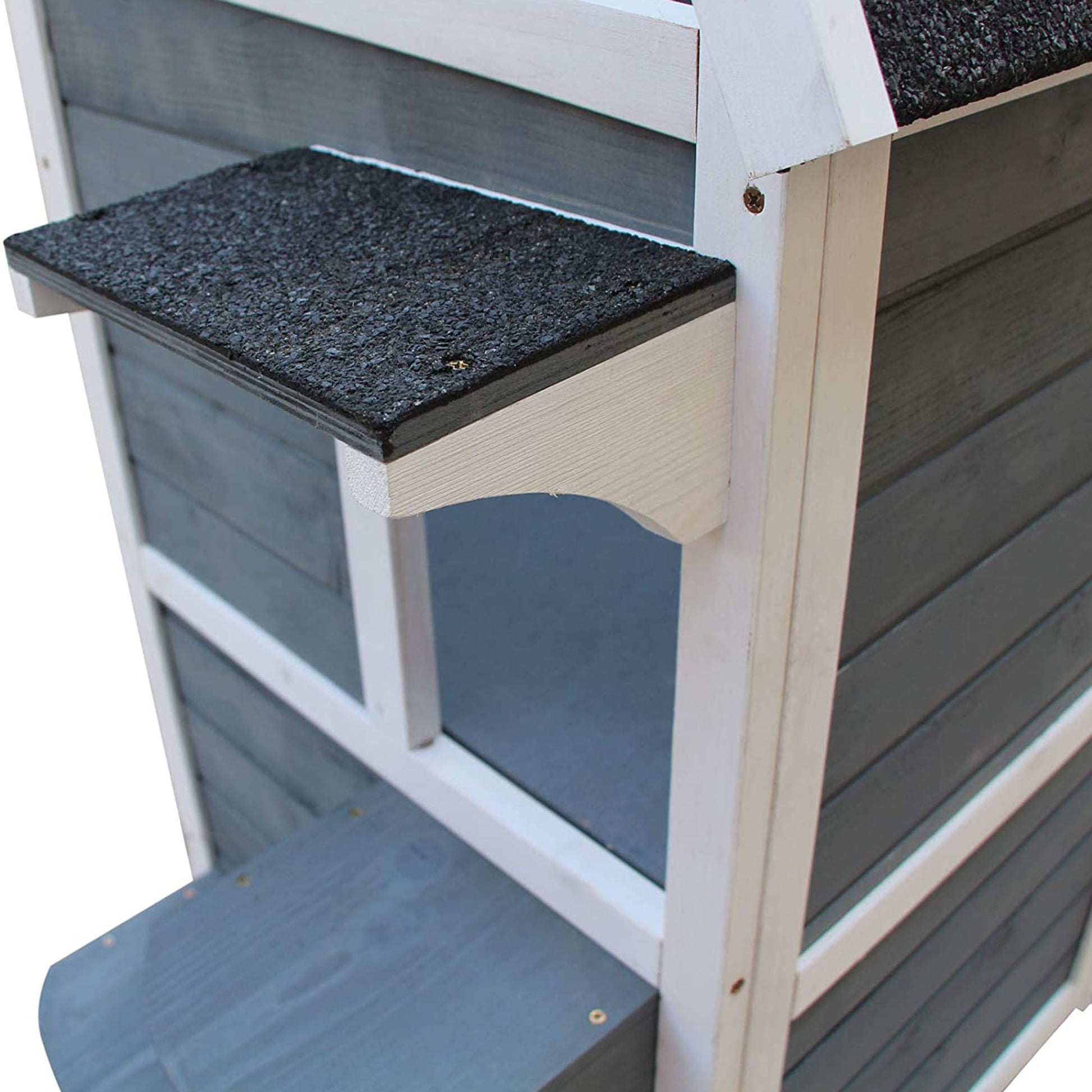 Closeup of a grey and white outdoor cat house with a textured platform perfect for feline comfort